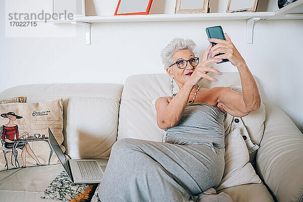 Frau mit Videoanruf auf Telefon zu Hause