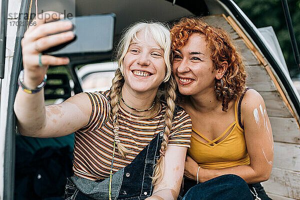 Lesbisches Paar lächelt und macht ein Selfie