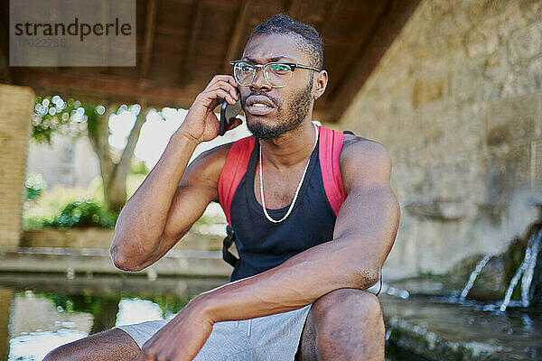 Junger Mann beim Telefonieren im Freien
