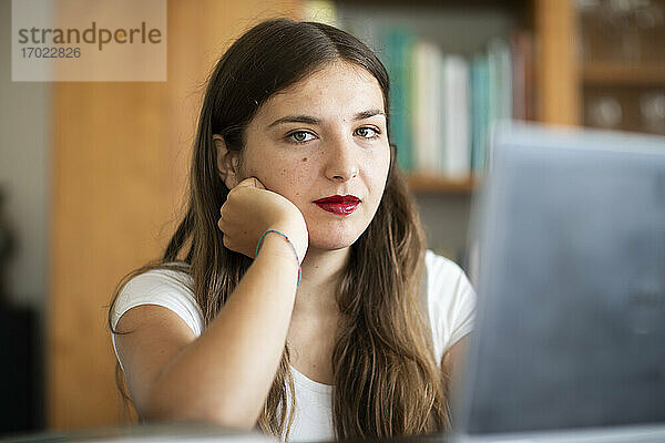 Junge Frau arbeitet am Computer in einer Bibliothek