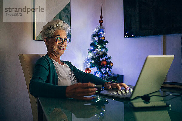 Frau auf Laptop Videoanruf  Weihnachtsbaum im Hintergrund