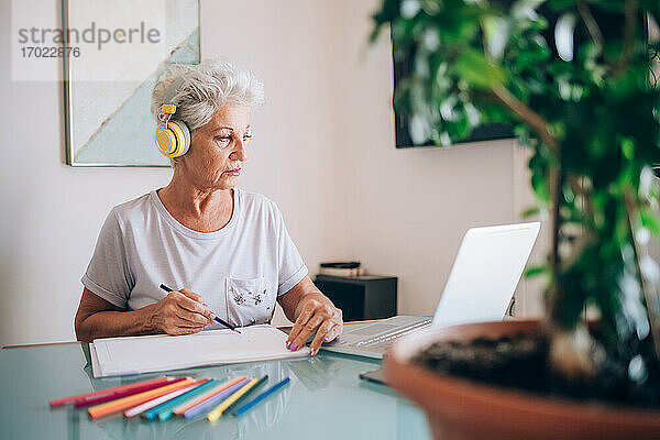 Frau  die zeichnet und einen Online-Kunstkurs belegt