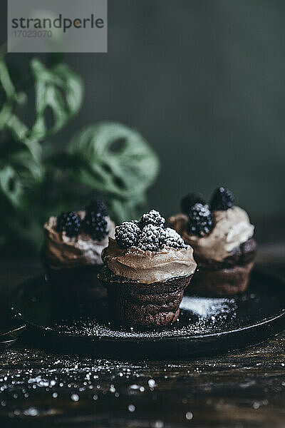 Schokoladencupcakes mit Kaffeecreme  Brombeeren und Puderzucker