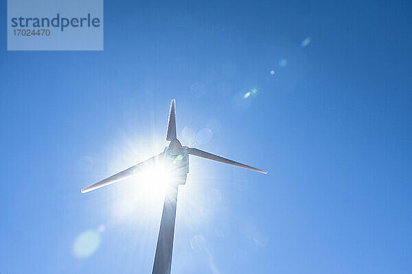 Niedriger Winkel Ansicht der Windkraftanlage gegen blauen Himmel und Sonne