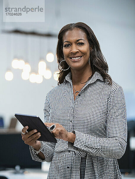 Porträt einer Geschäftsfrau  die ein digitales Tablet hält