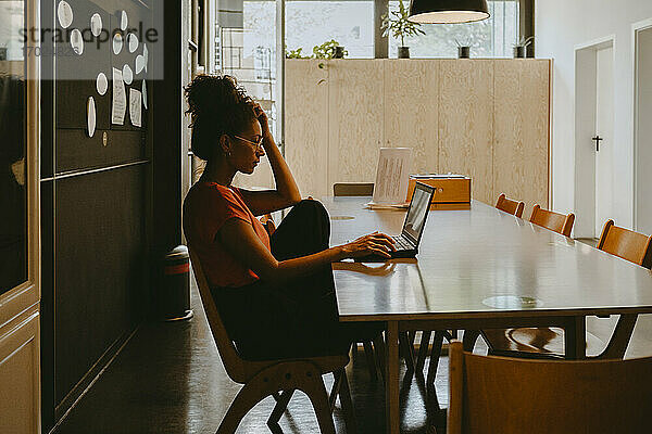 Weibliche Unternehmerin arbeitet am Laptop im Büro