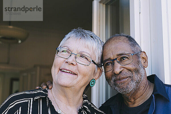 Lächelndes älteres Ehepaar  das gegen die Tür wegschaut
