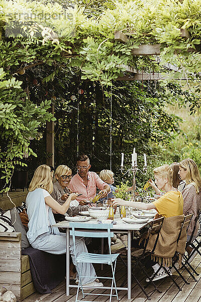 Glückliche Familie beim Essen auf der Gartenparty