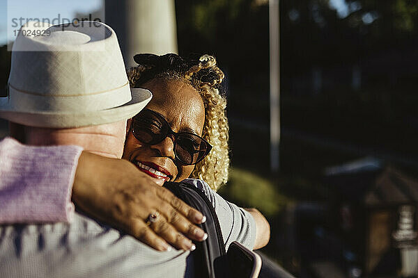 Senior Frau umarmt Mann am sonnigen Tag