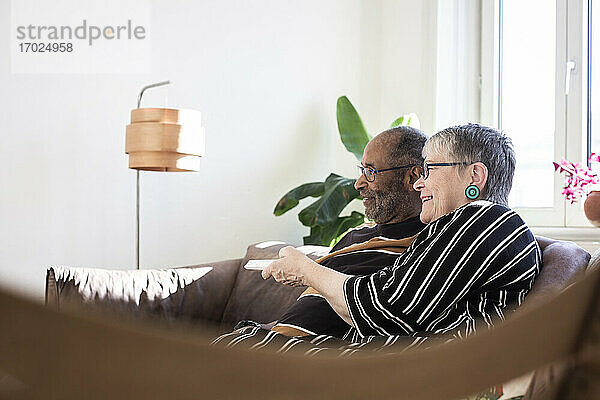 Glückliches Paar beim Fernsehen im Wohnzimmer