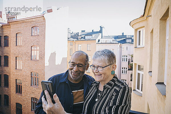 Älteres Paar nimmt Selfie durch Handy in Balkon