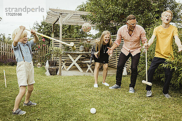 Fröhliche Familie spielt Polo im Vorgarten
