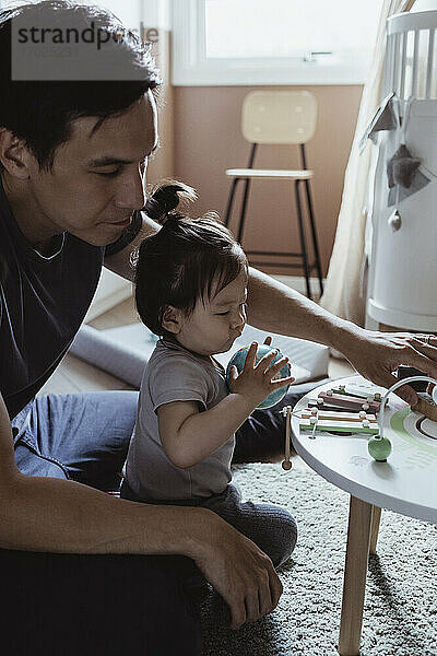 Vater und Baby Sohn spielen mit Spielzeug im Wohnzimmer