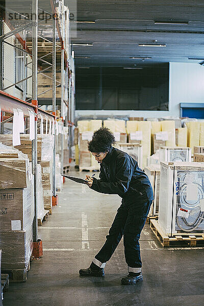 Weiblicher Arbeiter bei der Analyse von Boxcontainern im Auslieferungslager