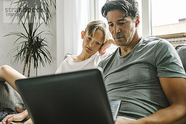 Vater und Sohn verwenden Laptop zu Hause