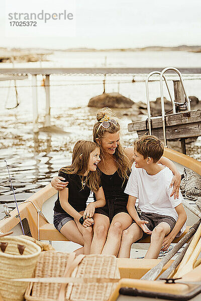 Glückliche Familie sitzt im Boot während des Sommerurlaubs