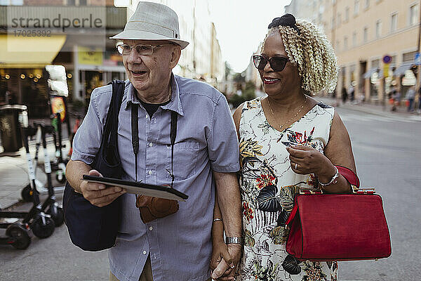 Glückliche Senior Paar zu Fuß in der Stadt