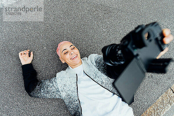 Fotograf liegt auf dem Boden und nimmt Selfie mit Kamera