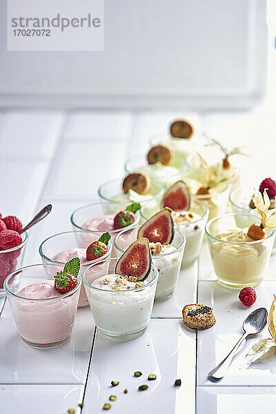 Verschiedene Joghurtdesserts mit Früchten in kleinen Gläsern