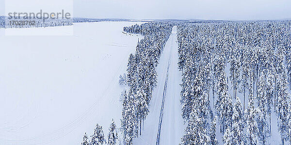 Gefährliche Straßenverhältnisse auf einer eisigen  schneebedeckten Winterstraße am Polarkreis in Lappland  Finnland Drohne