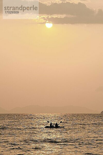 Touristenpaar beim Seekajakfahren bei Sonnenaufgang am East Railay Beach  Südthailand. Railay Beach (Rai Leh Beach) ist ein atemberaubendes thailändisches Urlaubsziel in der Nähe von Krabi  an der Andamanenküste Thailands. Das tropische Paradies Railay (Rai Leh)  das nur mit einem traditionellen thailändischen Boot erreichbar ist  weil es von riesigen Kalksteinkarstfelsen umgeben ist  beherbergt eine Reihe wunderschöner exotischer Strände  darunter Ao Phra Nang  East Railay und West Railay Beach.