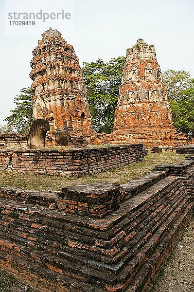 Tempelruinen im Wat Mahathat in der alten Stadt Ayutthaya  Thailand. Wat Mahathat  eine der vielen alten Tempelruinen in Ayutthaya City  ist bei Touristen wahrscheinlich am bekanntesten wegen des ikonischen großen Buddha-Kopfes  der von Feigenbaumwurzeln umschlungen wird. Der Historische Park der alten Stadt Ayutthaya  Phra Nakhon Si Ayutthaya  beherbergt die Ruinen von Tempeln und Buddhas aus der Zeit  als die Stadt die Hauptstadt des Königreichs Siam war. Die historische Stadt Ayutthaya wurde 1991 in die Liste des UNESCO-Weltkulturerbes aufgenommen.