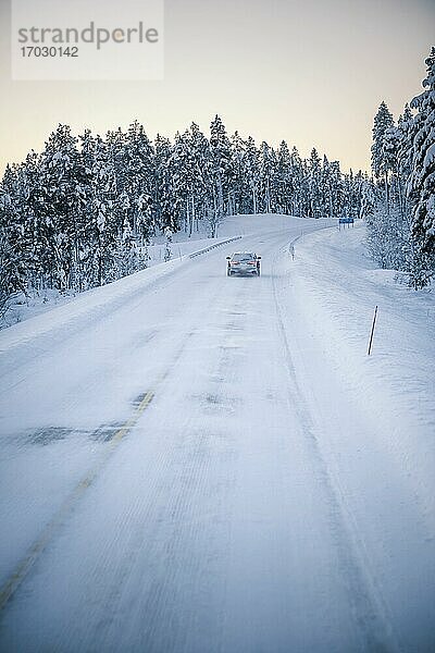 Autofahrt auf vereisten  schneebedeckten Straßen während einer Reise in Lappland innerhalb des Polarkreises in Finnland