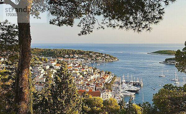 Foto von Hvar Stadt bei Sonnenuntergang  Insel Hvar  Kroatien  Europa. Dieses Foto der Stadt Hvar und des Hafens wurde bei Sonnenuntergang von der Wanderung hinauf zur Spanischen Festung aufgenommen. Vom Hügel oberhalb der Stadt Hvar aus hat man die besten Fotomöglichkeiten und Ausblicke auf die Stadt Hvar  den Hafen und die Insel Hvar  besonders bei Sonnenuntergang.