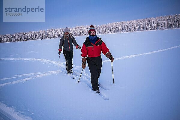 Skifahren auf dem zugefrorenen See von Torassieppi bei Sonnenuntergang  Lappland  Finnland