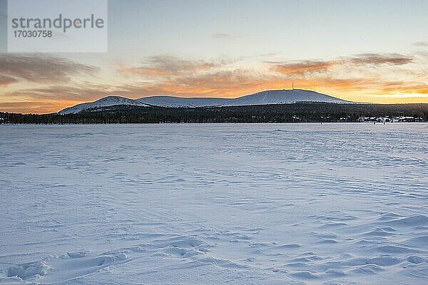 Kalte schneebedeckte eisige Winterlandschaft bei Sonnenuntergang innerhalb des Polarkreises in Lappland in Finnland