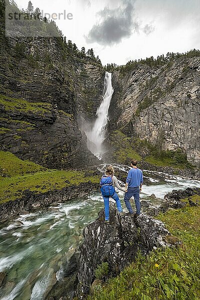 Zwei Wanderer  Pärchen  stehen auf Felsen an Fluss Driva  Wasserfall Svøufallet  Åmotan Schlucht  Gjøra  Norwegen  Europa