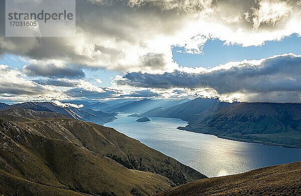 Sonnenstrahlen scheinen durch Wolkenhimmel  Blick auf Lake Wanaka im Abendlicht  See und Berglandschaft  Ausblick vom Isthmus Peak  Wanaka  Otago  Südinsel  Neuseeland  Ozeanien