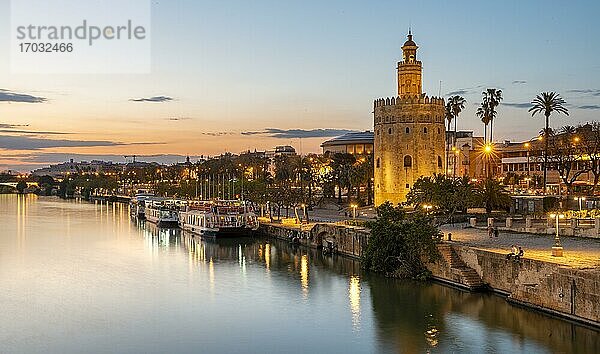 Blick über den Fluss Rio Guadalquivir mit Torre del Oro und Uferpromenade mit Ausflugsbooten  Sonnenuntergang  blaue Stunde  Sevilla  Andalusien  Spanien  Europa