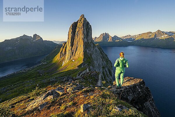 Morgenstimmung  Wanderin blickt auf Landschaft  steiler Berg Segla  Fjord Mefjorden mit Bergen  Insel Senja  Troms  Norwegen  Europa