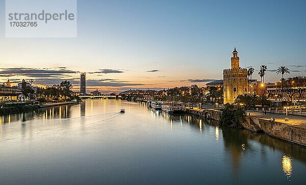 Blick über den Fluss Rio Guadalquivir mit Torre del Oro  Uferpromenade und Puente de Triana  hinten Torre Sevilla  Sonnenuntergang  blaue Stunde  Sevilla  Andalusien  Spanien  Europa