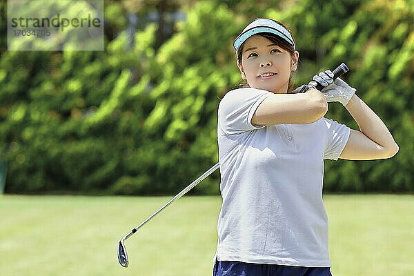 Japanerin übt Golf im Garten