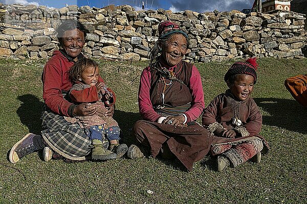 Frauen und Kinder sitzen in der Abendsonne auf einer Wiese  Shey Gompa  Dolpo  Nepal  Asien