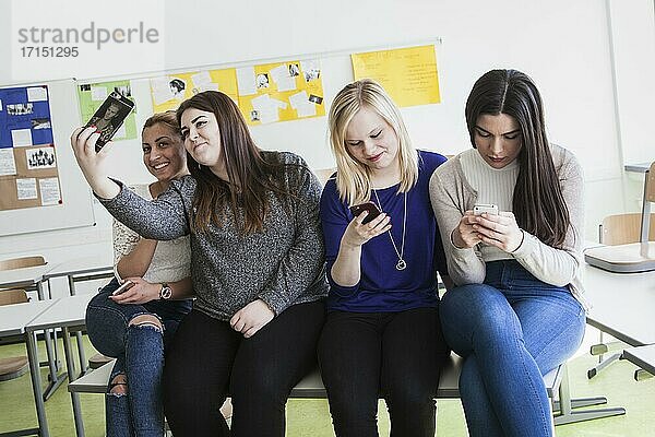 Berufsschülerinnen mit ihren Smartphones während der Pause in der Elly-Heuss-Knapp-Schule  ein Berufskolleg der Stadt Düsseldorf  Nordrhein-Westfalen  Deutschland  Europa