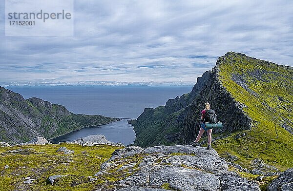 Wanderin blickt auf den Djupfjorden  Wanderung zur Munkebu Hütte  Berge  bei Sørvågen  Moskenesøya  Lofoten  Nordland