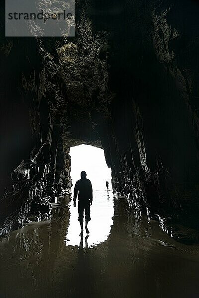 Silhouette einer Person vor Höhlenausgang im Gegenlicht  vom Meer ausgewaschene Höhle  Cathedral Cave  Waipati Beach  The Catlins  Southland  Südinsel  Neuseeland  Ozeanien