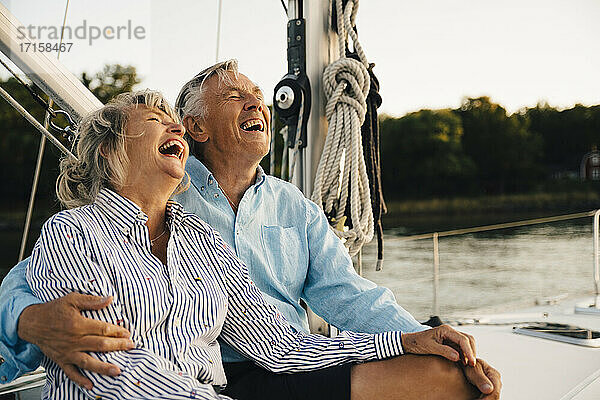Fröhliches Paar lachend bei der Freizeitgestaltung im Segelboot