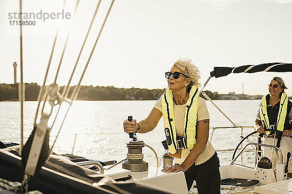 Senior Frau Segeln mit weiblichen Freund in Boot auf sonnigen Tag