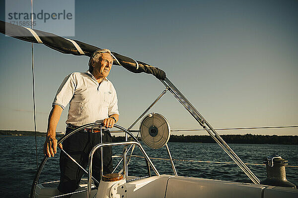 Aktive ältere Mann Segelboot gegen klaren Himmel an einem sonnigen Tag