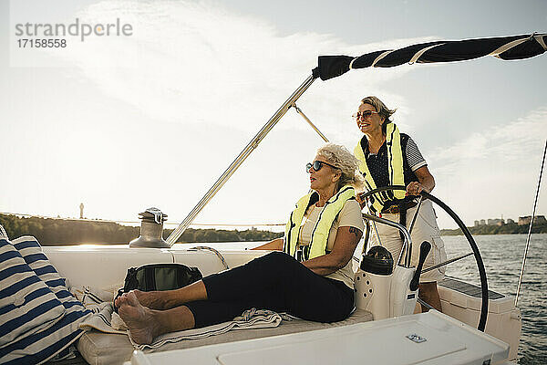 Fröhliche ältere weibliche Freunde im Boot an einem sonnigen Tag