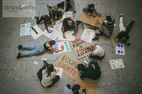 Direkt über einem männlichen und weiblichen Demonstranten  die Plakate für eine soziale Bewegung vorbereiten