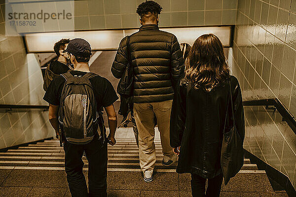 Rückansicht von Freunden  die in der U-Bahn nach unten fahren