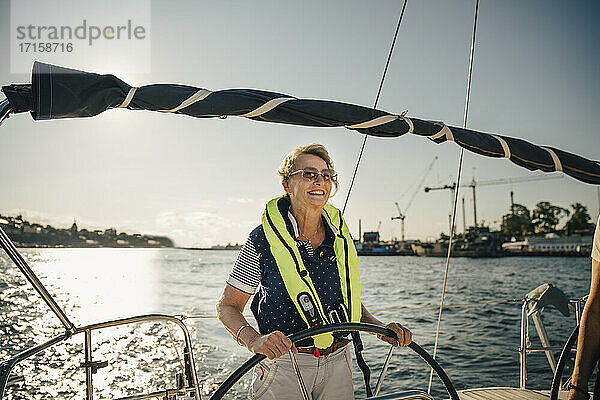 Lächelnde ältere Frau Segelboot auf sonnigen Tag