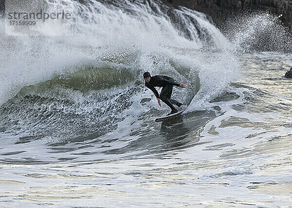 Männlicher Surfer beim Surfen auf dem Meer am Broad Haven South Beach  Wales  UK