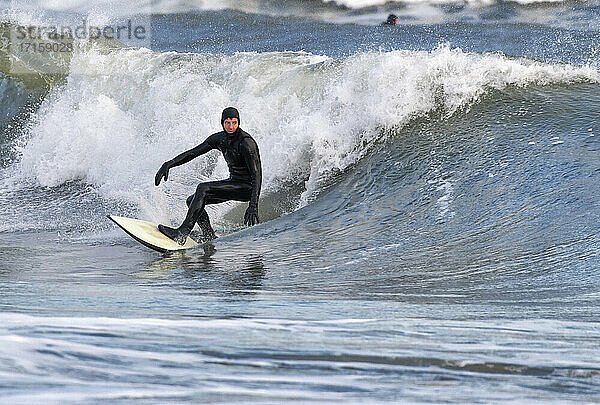 Mittlerer Erwachsener mit Neoprenanzug beim Surfen auf dem Meer  Broad Haven South Beach  Wales  UK