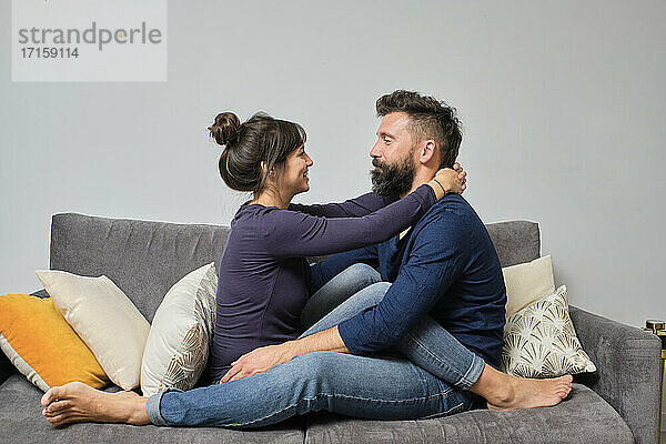 Erwachsenes Paar sitzt zusammen auf dem Sofa